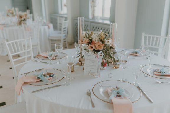 Elegantly gedeckter Tisch mit Blumenarrangement und feinem Geschirr.